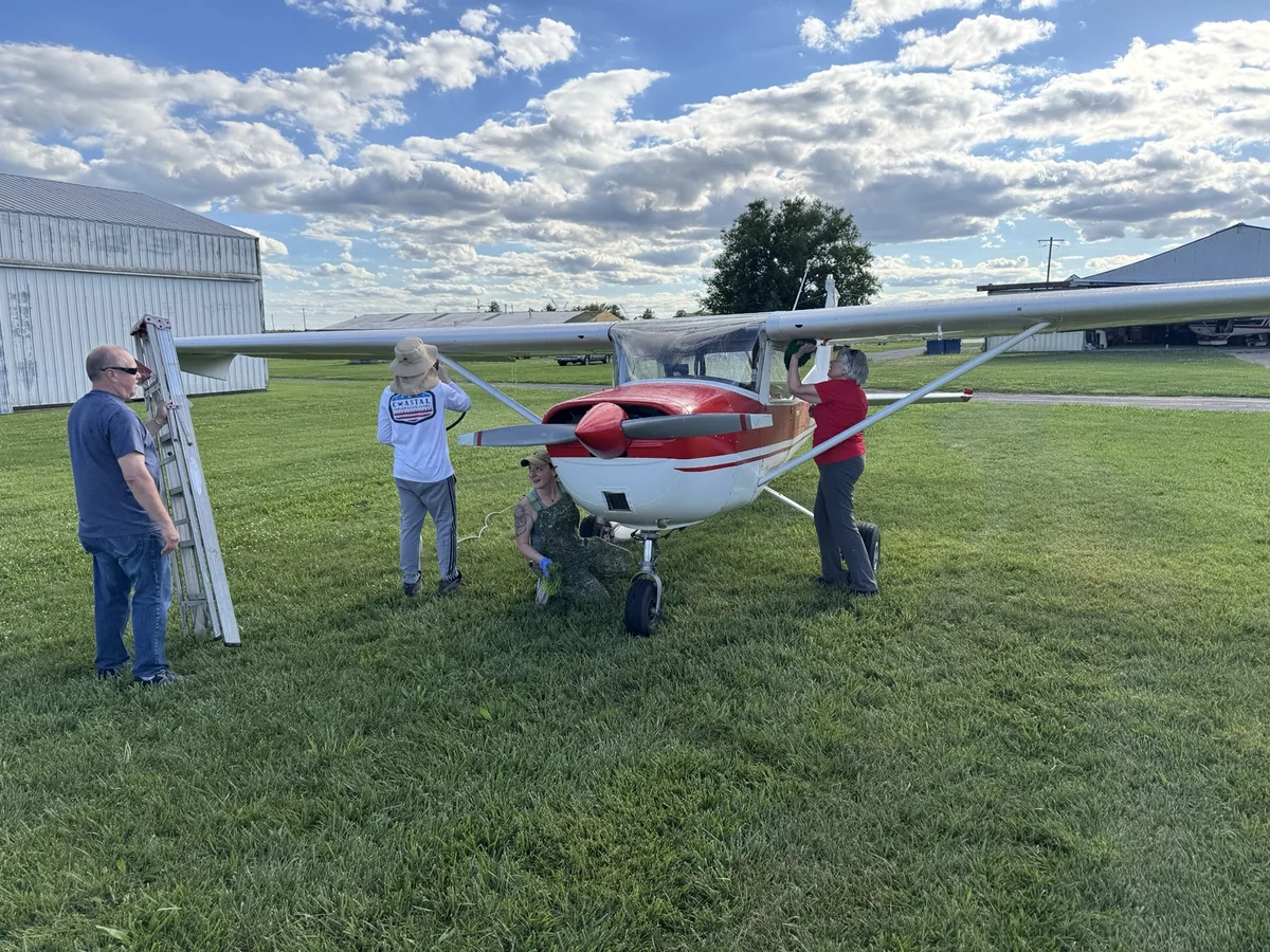 Open Hangar Collective members working together around a club aircraft